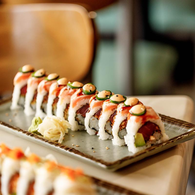 Chabad Roll topped with salmon, jalapeno slices and dots of sauce.